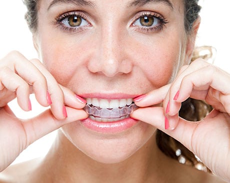 Patient holding a clear Invisalign aligner